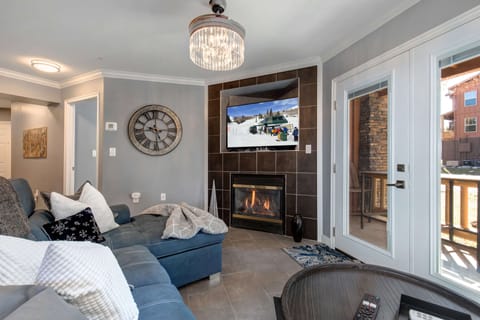 Sink into plush seating beside a warm fireplace while the mountain slopes call to you on screen. Your cozy retreat blends elegant comfort with alpine charm, opening to private balcony views.