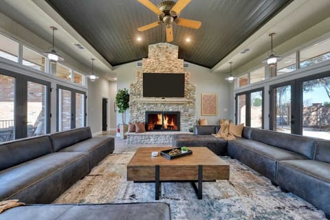 Great room with vaulted ceiling and stone fireplace has direct views of the Guadalupe RIver