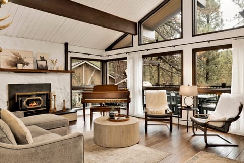 Spacious living room with glowing fireplace, cozy seating, and soft lighting creating a warm retreat