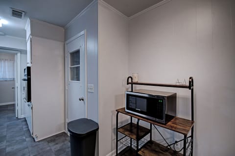 The kitchen with a microwave and storage area. The garage door is off of the kitchen.