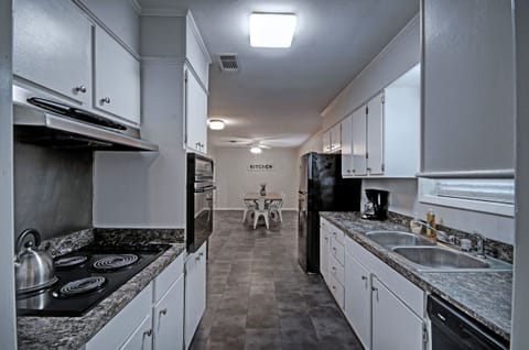 Kitchen with a stove, oven, refrigerator, dishwasher, microwave, 12-cup programmable coffee pot, and crock pot. Great for long stays.