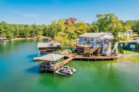 House surrounded by water on three sides, large dock area.