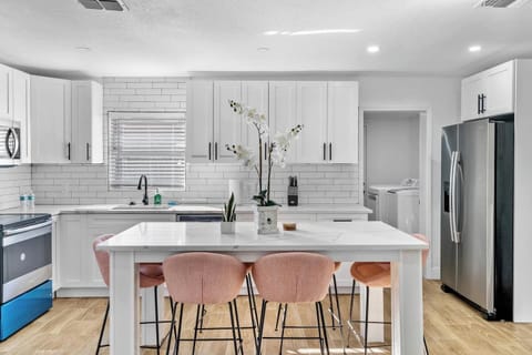 Modern kitchen with quartz counters, stainless appliances, and seating for four - perfect for meals or morning coffee