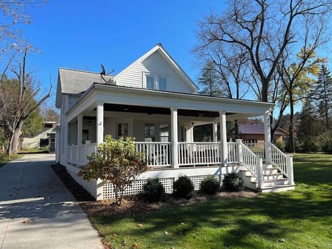 Front view of Home with large driveway that provides plenty of space for multiple vehicles. The wraparound porch includes outdoor furniture that is perfect for relaxing in the fresh air.