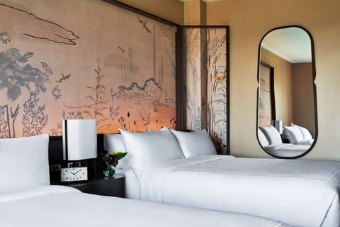 Unwind into crisp linens beneath striking, storybook wall art.