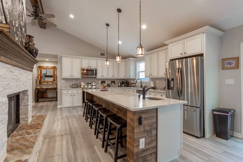 Kitchen fit for a master chef, with full-sized stainless-steel appliances and two sinks. Seating for five at the island.