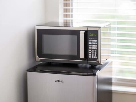 Convenient kitchenette with mini fridge, microwave and essentials for snacks and easy meals.