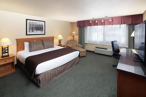 Sink into a plush king bed beside a relaxing armchair.
