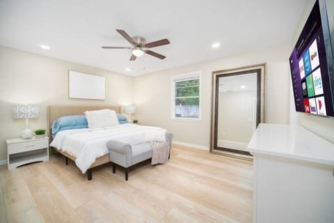 Cozy and modern bedroom with a comfortable bed, smart TV, and ample natural light for a restful stay.
