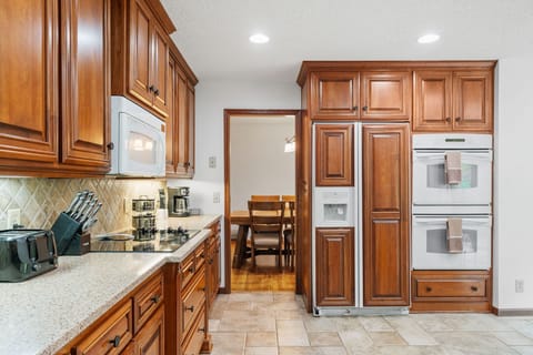 Cook your favorite meals in this elegant kitchen with rich wood cabinetry, granite counters, and premium appliances.