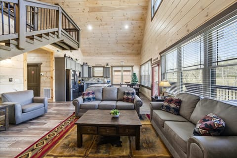 Relax in your spacious open-concept retreat with soaring wood ceilings, plush seating, and mountain views through expansive windows.