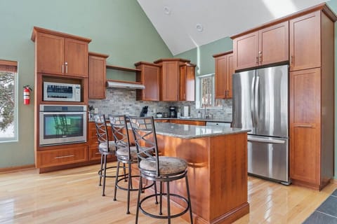 Fully- equipped kitchen with countertops and 3 stools