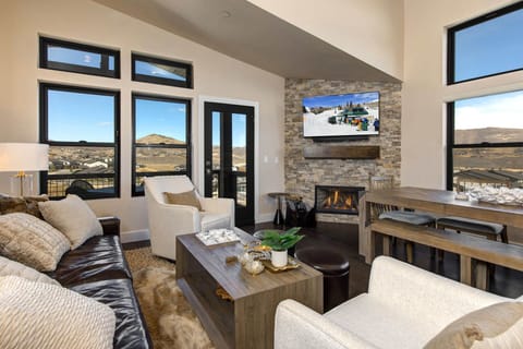 Mayflower Lakeside 1121-304: The living room is a bright, elegant space with mountain views, a large HDTV, and a cozy stone fireplace.