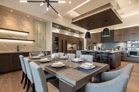 Open fully equipped kitchen, and dining area with gas range, stone countertops, and large dining room table with ample seating