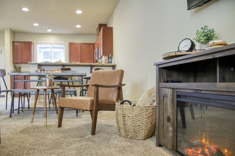 Unwind in a cozy living room with an armchair, fireplace, and spacious dining area.