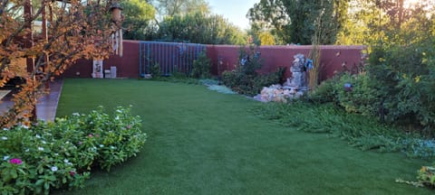 Ornate yard with water feature and artificial turf.
