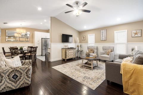 Spacious living room. Equipped with a smart TV, three accent chairs and a sofa. 