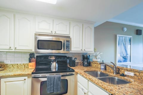 The kitchen features stainless steel appliances and granite countertops.