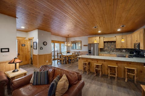 Cozy up in this warm open living space where rich wood beams overhead create cabin charm while you cook, dine, and relax together.
