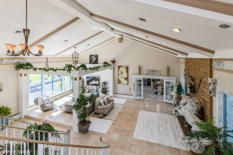Living room with oversized fireplace, bay views, and double bridal staircase. 