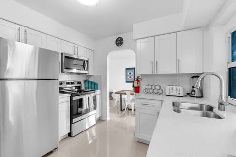 "Cook with ease in this sleek Airbnb kitchen—white cabinets, stainless steel appliances, and open flow to dining make it perfect for family meals and long-term stays."