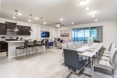 Living area showing dining table, breakfast bar, and living room.