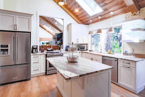 The kitchen features granite countertops, white cabinets and designer lighting fixtures.