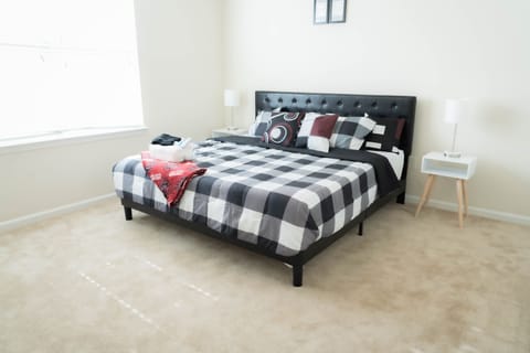 King bed with black and white Comforter (White too).  White end tables .