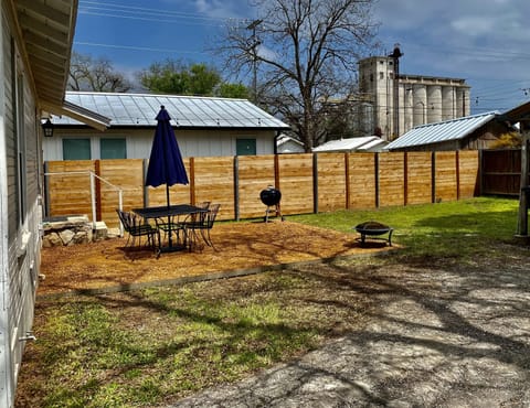 Outside dining area with charcoal grill and small fire pit for s’mores.
