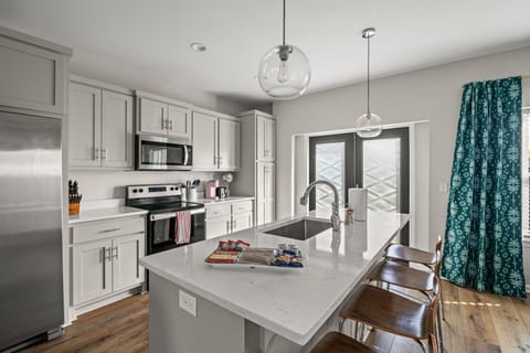 Fully stocked kitchen with quartz countertops and stainless steel appliances