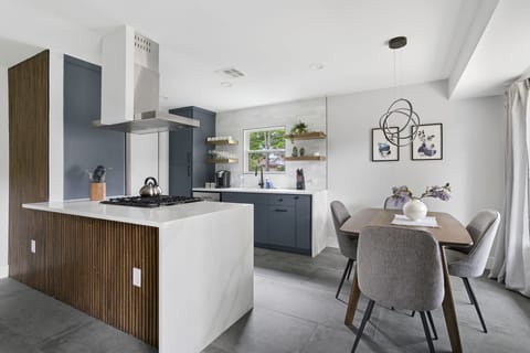 Modern kitchen with sleek island, stainless appliances, and a bright dining area