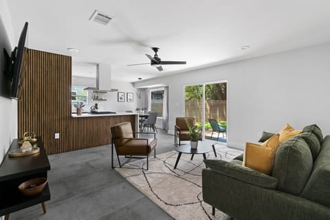 Open living with modern décor, smart TV, and backyard access