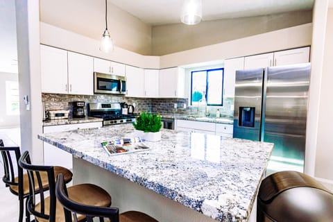 Modern kitchen is fully stocked and furnished with stainless steel appliance