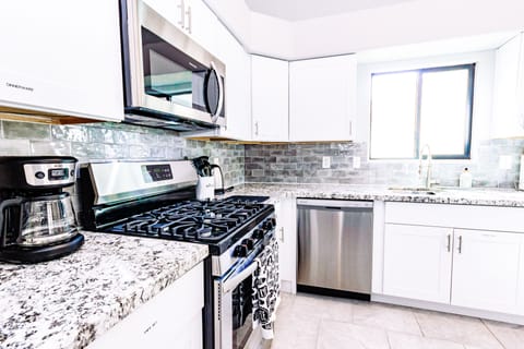Modern kitchen is fully stocked and furnished with stainless steel appliance