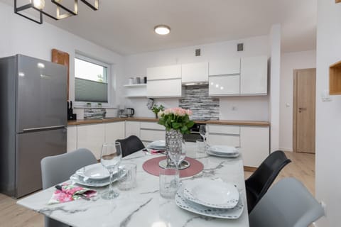 A dining area with a table set for a family meal, seamlessly blending with the open-plan kitchen.
