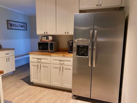Large stainless steel refrigerator with water and ice on the door.
