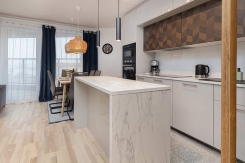 A modern kitchen with wooden cabinets, a sleek island, and all necessary appliances.