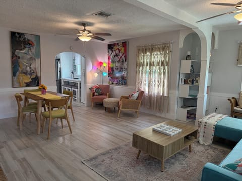 Open concept living/dining/sitting area leading to galley kitchen through arch.