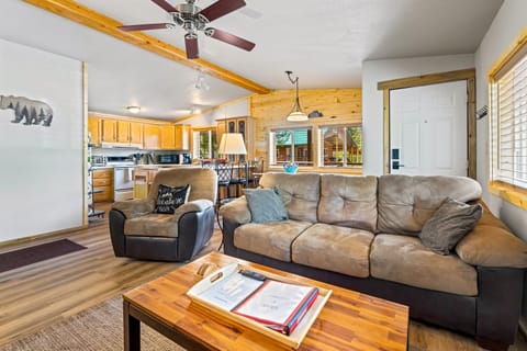 Immerse yourself in the inviting living room of the Ponderosa Pine cabin, featuring a spacious four-seat island seamlessly connected to a well-appointed kitchen in the background, creating the