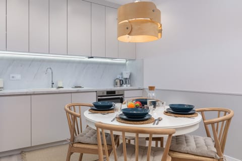 A modern kitchen with sleek white cabinetry, an induction cooktop, and all essential appliances.