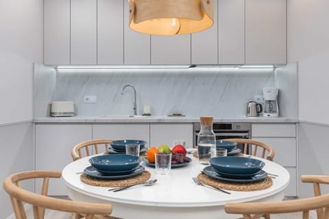 A modern kitchen with sleek white cabinetry, an induction cooktop, and all essential appliances.