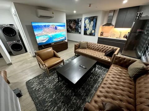 Lounge room with 85" high resolution Sony digital TV and open plan kitchen