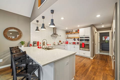 Quartz-topped island with pendant lighting and wraparound breakfast bar