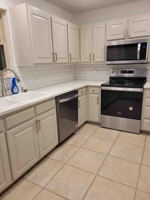 The kitchen includes a coffee maker, microwave, oven (with built-in air fryer), and dishwasher. 