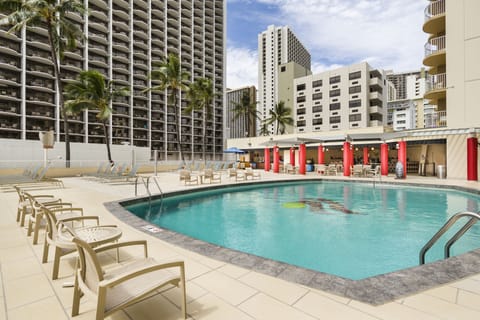 Dive into a sunlit pool oasis with plenty of loungers.