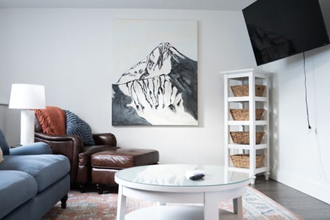 Living room with custom Lone Peak art and 55" smart TV.