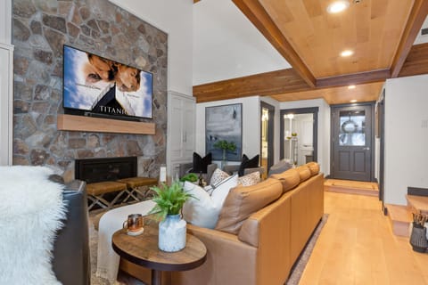 Living Room with leather sectional/sofa sleeper, arm chairs, gas fireplace, and 75" Smart TV