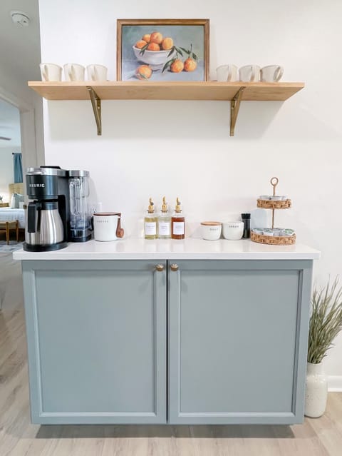 Beverage station with complimentary coffee & tea. Cocktail glasses in cabinet.