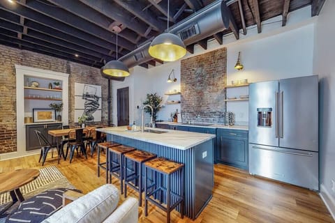 Kitchen: Our kitchen has a spacious counter, organized wooden cabinets, stainless steel appliances, and utensils.