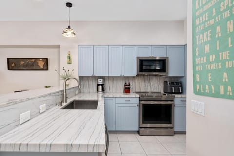 Full kitchen with marble style counters and stainless steel appliances